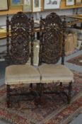 A pair of carved oak high back chairs.