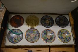 A cased set of eight Chinese cloisonne dishes showing the various stages of cloisonne production.