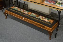 A long foot stool with embroidered decoration.