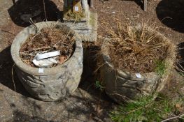 A pair of composite garden plant pots.