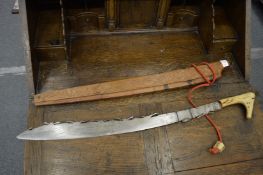 A bone handled head hunters sword with carved wood scabbard.