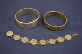 Two engraved silver bangles and a coin bracelet.