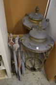 A pair of large brass hanging lanterns with cast iron brackets (lacking glazing).