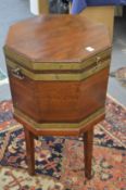 A George III mahogany and brass bound octagonal shaped cellarette on stand.