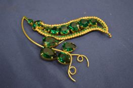 A decorative green stone leaf shaped brooch, signed.