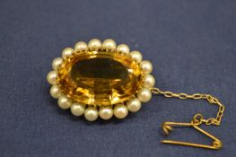 A 9ct gold brooch set with a central oval citrine coloured stone framed by seed pearls.
