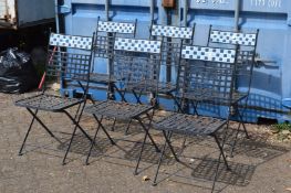 A set of six wrought iron and tile folding garden chairs.
