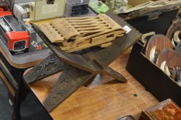 A carved wood folding Quran stand and another stand.