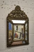 A small decorative pressed brass framed mirror.