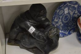 An Inuit carved hard stone group of an Eskimo and walrus (faults).