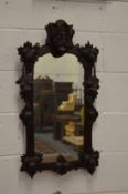 A small mirror with heavily carved oak frame depicting a kings head.