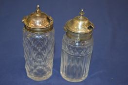 Two silver topped cut glass cruets.