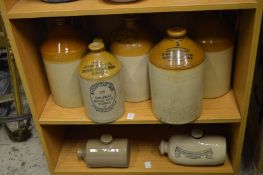 A small collection of stoneware, ginger beer and other storage bottles and two foot warmers.