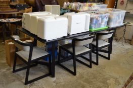 A large black ash rectangular dining table and four chairs.