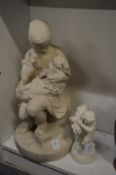 A Parian group of a girl holding a puppy in her lap (faults) together with a smaller group.