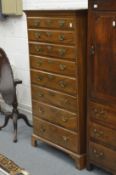A George III mahogany tall chest of eight graduated long drawers on bracket feet.