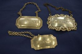 Three silver decanter labels.