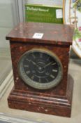 A rouge marble mantel clock.