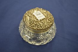 A silver topped cut glass dressing table jar.