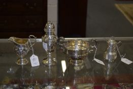 A silver twin handled pedestal cup, an embossed silver cream jug, a sugar castor and a stylish