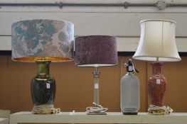Three decorative table lamps and a soda syphon.