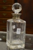 A cut glass whisky decanter with silver collar.