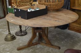 A large circular hardwood pedestal dining table.
