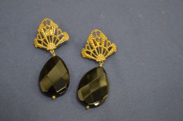 A pair of silver gilt earrings with amethyst colour stones.