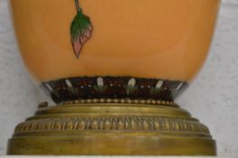 A large cloisonne lamp base with floral decoration.
