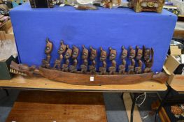 A carved wood dragon boat and figures.