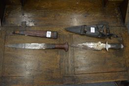 An African dagger with decorative leather scabbard and another dagger.