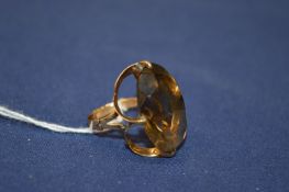 A 14ct gold ring set with an oval shaped stone, possibly smoky quartz.