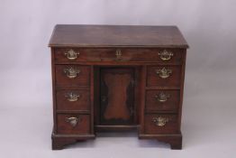A GEORGE III MAHOGANY KNEEHOLE DESK, with a long frieze drawer, central cupboard flanked by three