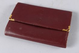 A VINTAGE CARTIER BURGUNDY LEATHER PURSE.