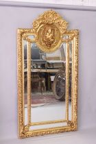 A LARGE DECORATIVE GILT FRAMED SECTIONAL MIRROR, with an oval panel depicting a bust of a young