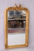 A DECORATIVE GILT FRAMED PIER MIRROR, with musical trophies cresting, 5ft high x 2ft 9in wide.