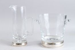 A GOOD GLASS ICE BUCKET with silver base. 20cm high and A WATER JUG, 25cm high.