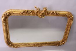A DECORATIVE GILT FRAMED OVER-MANTEL MIRROR, with musical trophies cresting, 4ft 7in wide x 3ft
