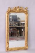 A DECORATIVE GILT FRAMED PIER MIRROR, with cherub cresting, 5ft high x 2ft 9in wide.