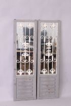 A PAIR OF GARDEN MIRRORS, with grey painted frames and wrought iron decoration, 4ft 11in high x