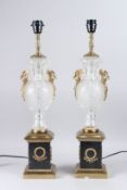 A PAIR OF GLASS URN SHAPED TABLE LAMPS, on square bronze bases, 25in high.
