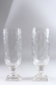 A PAIR OF CUT GLASS STORM LANTERNS on square bases. 13.5ins high.
