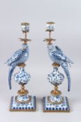 A LARGE PAIR OF BLUE AND WHITE PORCELAIN CANDLESTICKS, modelled as parrots seated on urns on