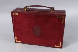 A VINTAGE CARTIER BURGUNDY SUEDE JEWEL BOX with carrying handles. 10.5ins x 7.5ins.