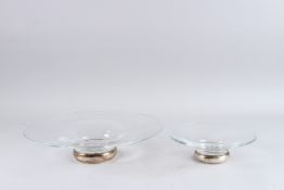 TWO GOOD GLASS CIRCULAR DISHES, 35cm wide and another smaller, 20cm wide, both with silver bases.