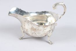 A VICTORIAN SILVER SAUCE BOAT, with scroll handle on three hoof feet, London 1896, maker D & J