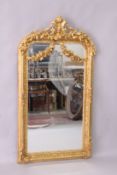 A DECORATIVE GILT FRAMED PIER MIRROR, with shield shape cresting, 5ft 2in high x 2ft 9in wide.