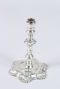 A GEORGE II SILVER TAPER STICK, the shaped foot engraved with a crest, London 1750, maker Simon