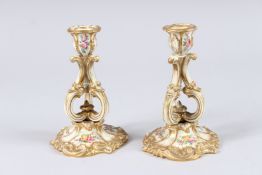 A PAIR OF LATE 19TH CENTURY PORCELAIN CANDLESTICKS, with 'C' scroll open work bodies and floral