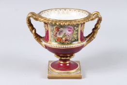 A WORCESTER PORCELAIN TWIN HANDLED PEDESTAL VASE, Rouge Royal ground, decorated with a panel of